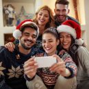 Young happy people making Christmas selfie